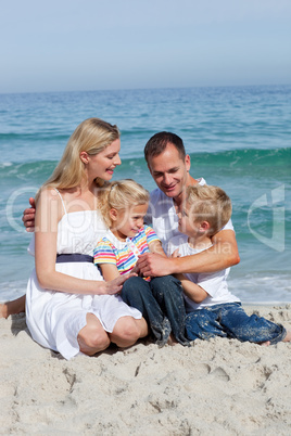 Portrait of an affectionate family sitting on the sand