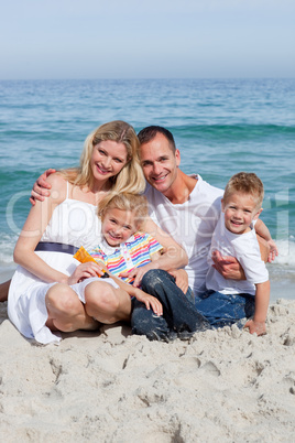 Portrait f a cheerful family holding suncreen