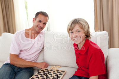 Caring father playing chess with his son