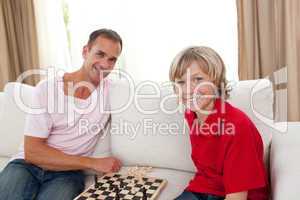 Caring father playing chess with his son