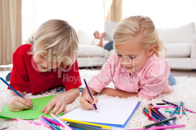 Concentrated children drawing lying on the floor