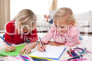Concentrated children drawing lying on the floor
