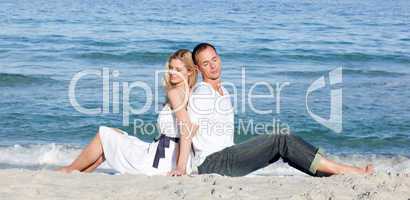 Romantic couple sitting on the sand