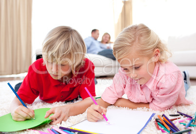 Cute siblings drawing lying on the floor