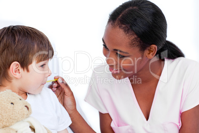 Smiling nurse taking little boy's temperature
