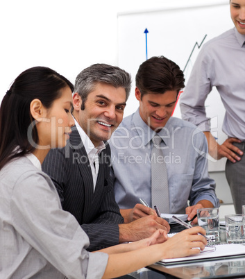Smiling mature manager in a meeting with his team