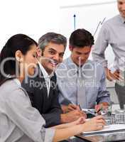 Smiling mature manager in a meeting with his team