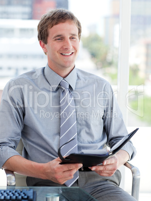 Charming male executive looking at his agenda