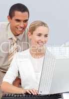 Joyful manager helping a businesswoman with her computer