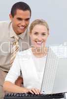 Positive manager helping a businesswoman with her computer
