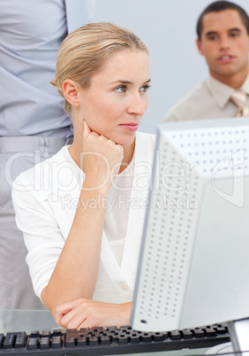 Pensive blond woman working at a computer