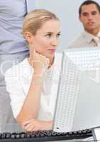 Pensive blond woman working at a computer