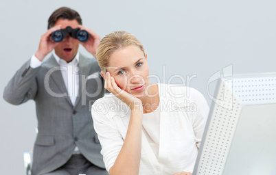 Charismatic manager holding binoculars looking at his colleague'