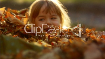 Kind im Blätterhaufen