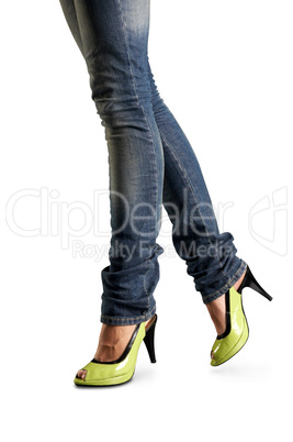 Female feet in jeans and in green shoes