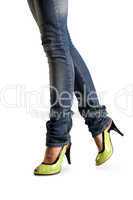 Female feet in jeans and in green shoes