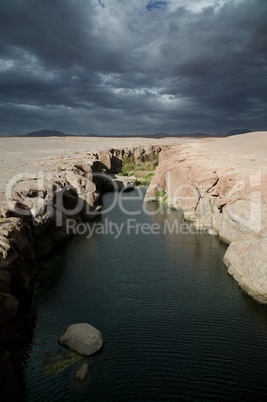 Canyon with river and heavy clouds