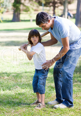 Confident father teaching baseball to his son