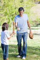 Adorable little boy playing baseball with his father