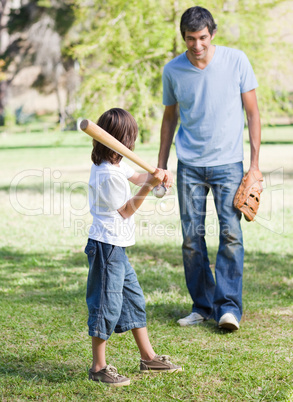 Cute little boy playing baseball with his father