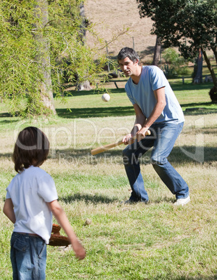 Athletic father playing baseball with his son