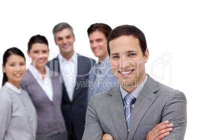 Smiling businessman with folded arms standing with his team
