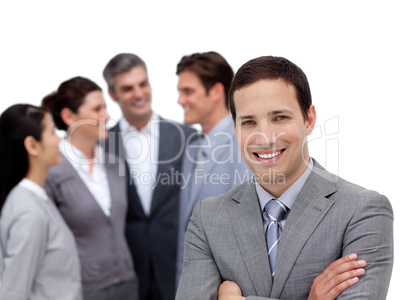 Positive businessman with folded arms standing with his team