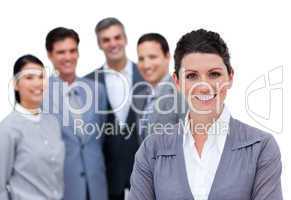 Happy businesswoman with folded arms standing with his team