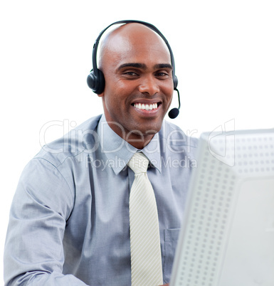 Happy businessman talking on headset at a computer