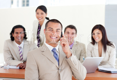 Assertive manager on phone in front of his team