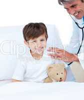Smiling doctor checking little boy's pulse
