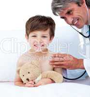 Mature doctor checking little boy's pulse