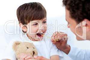 Male doctor taking little boy's temperature