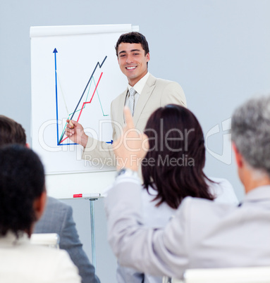 Mature businessman asking a question at a conference