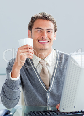 Young businessman drinking a coffe at his desk