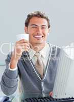 Young businessman drinking a coffe at his desk