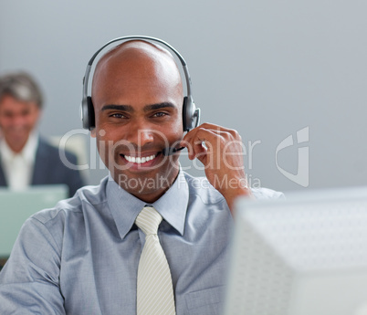 Charismatic  businessman with headset on working at a computer