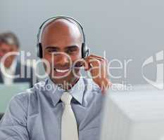 Charismatic  businessman with headset on working at a computer