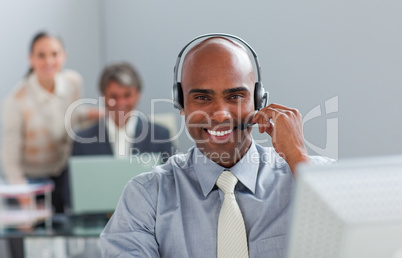 Afro-american  businessman with headset on working at a computer