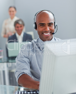 Confident  businessman with headset on working at a computer