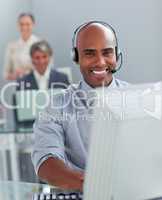 Confident  businessman with headset on working at a computer