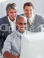 Positive businessmen helping their colleague at a computer