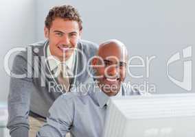 Young businessman helping his colleague at a computer