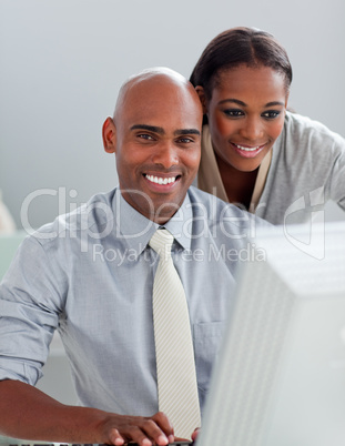 Charming businesswoman helping her colleague at a computer Charming businesswoman helping her colleague at a computer