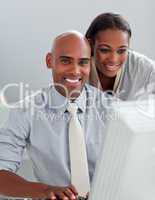 Charming businesswoman helping her colleague at a computer