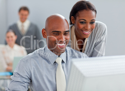 Smiling business partners working at a computer together