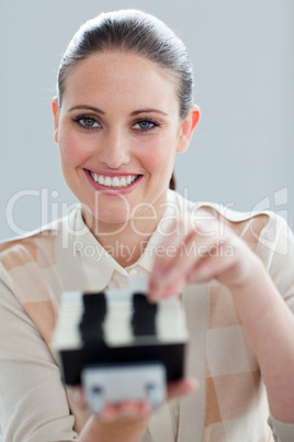 Self-assured businesswoman consulting a business card holder
