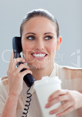 Young businesswoman on phone drinking a coffee