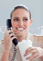 Young businesswoman on phone drinking a coffee