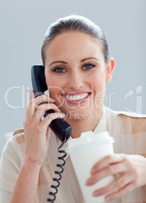 Caucasian businesswoman on phone drinking a coffee